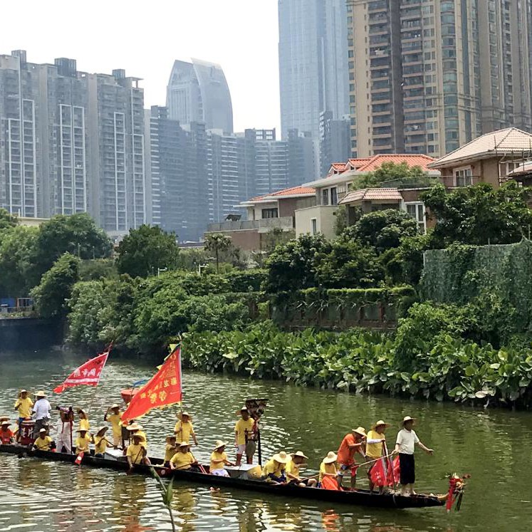 Traditional boat, meandering river, city backdrop