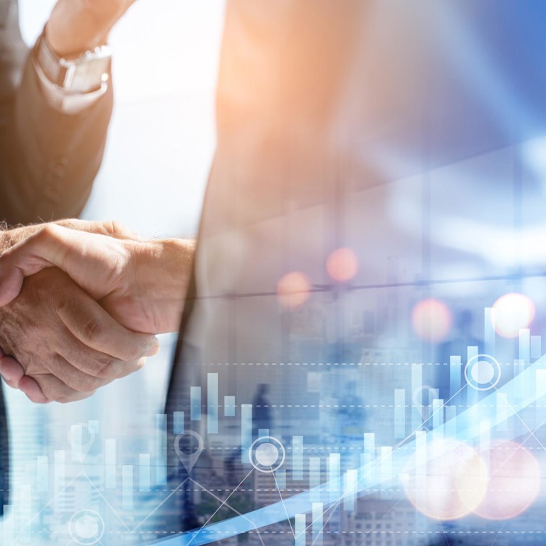 Two men shaking hands overlayed with graphs