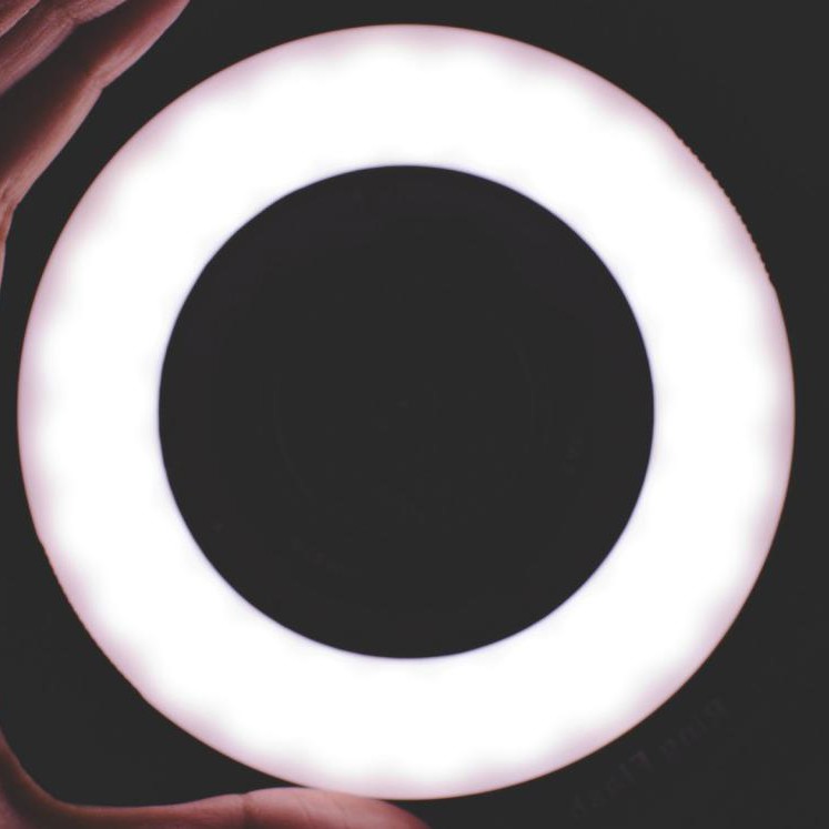 Silhouette of hand holding glowing futuristic ring
