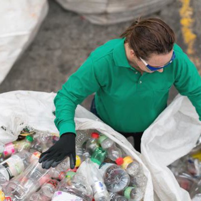 Person sorting bins of plastic bottles