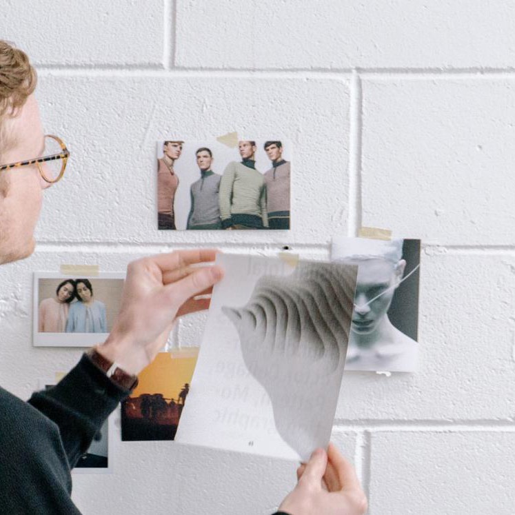 Images being placed on a white washed brick wall