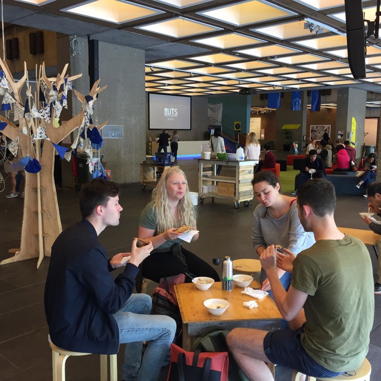 SDG students sitting at tables eating food