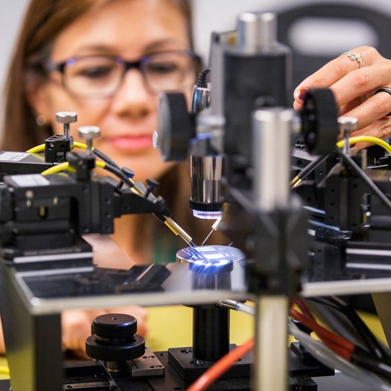 Woman wearing glasses works with lab equipment