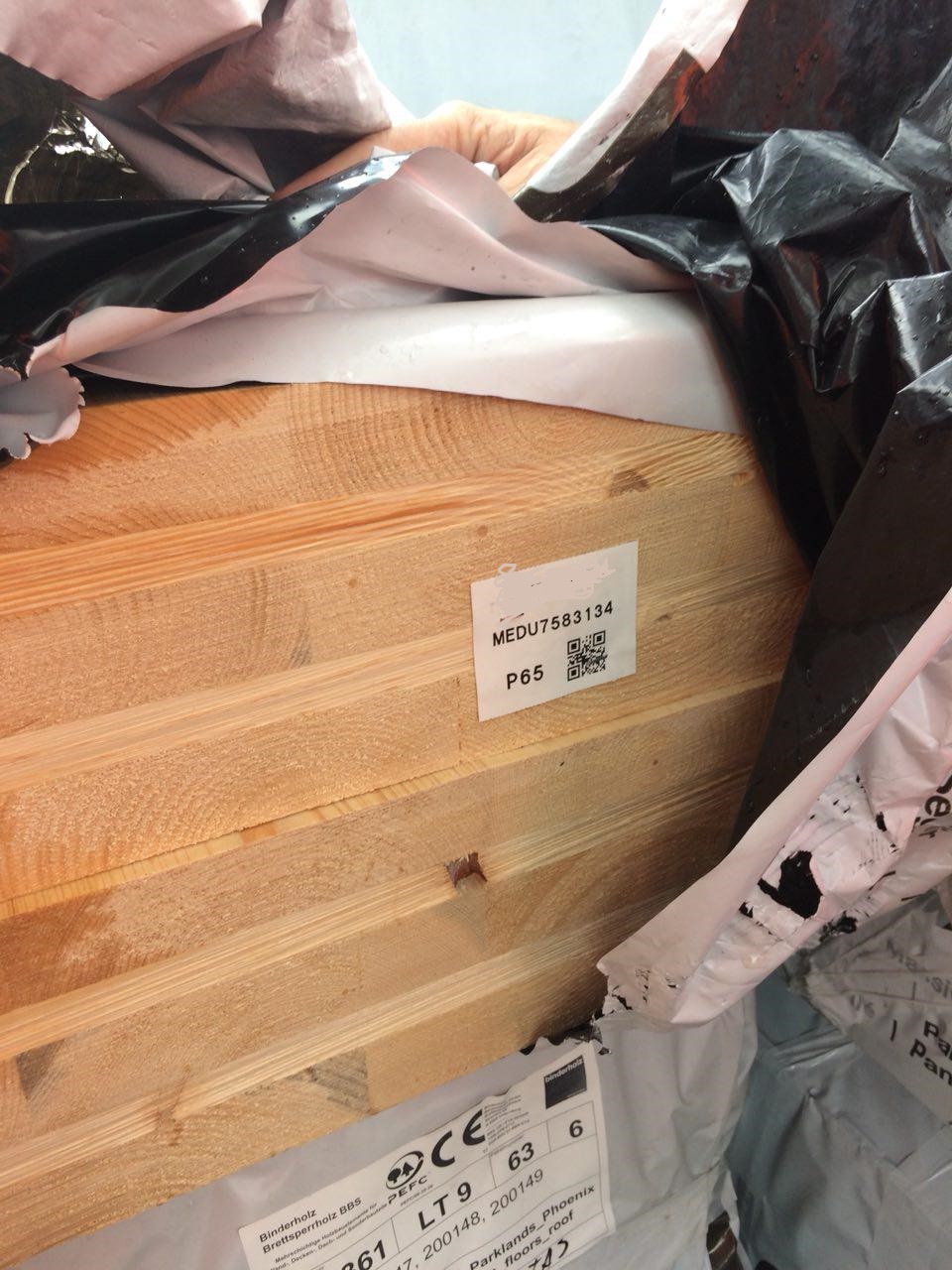 A close up of prefabricated timber with its plastic pulled aside showing its QR code.