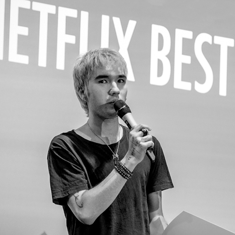 Oliver Whitehouse on stage receiving Netflix Best Director Award.