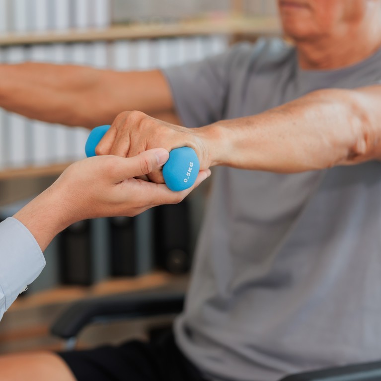 man lifting hand weights for rehabilitation.