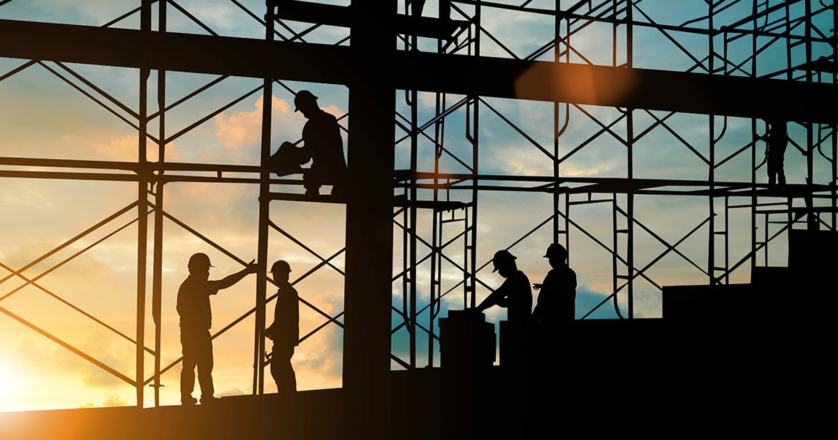 Sun setting behind a building site from inside the building