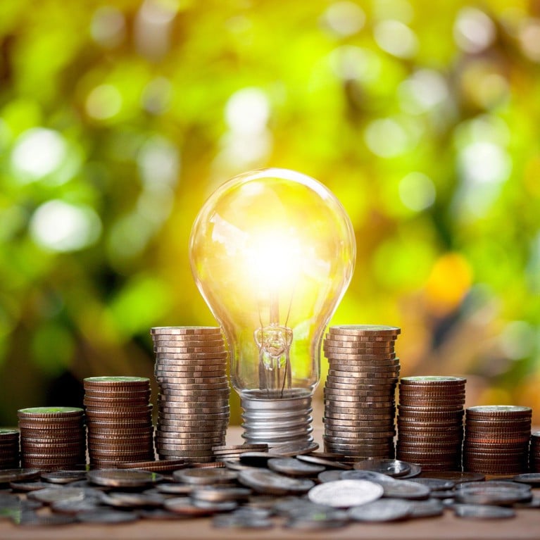 Lightbulb surrounded by coins