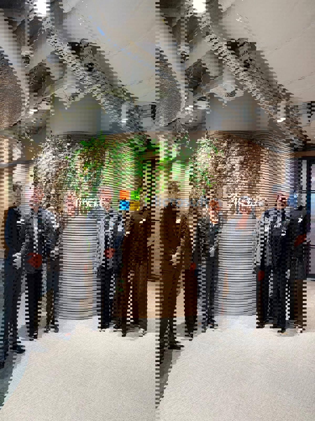 6 students in formal attire pose in front of a Microsoft logo