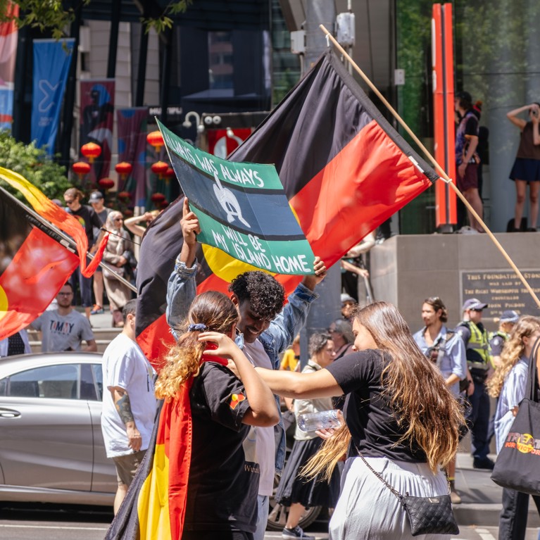 Image of a group of people with Aboriginal flags