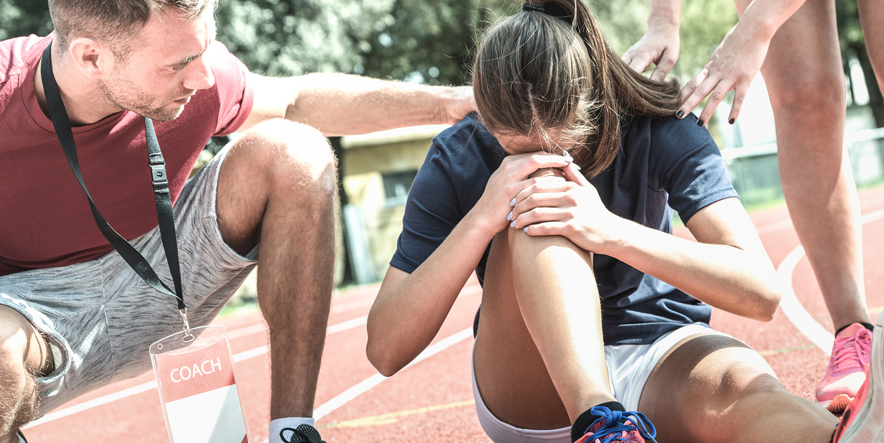 Injured runner being tended to by a coach
