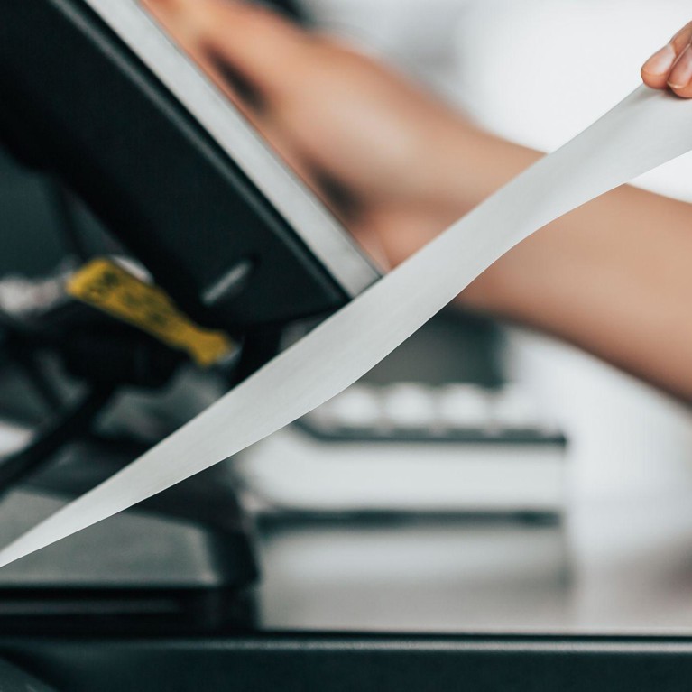 Women pulling a receipt out of a machine