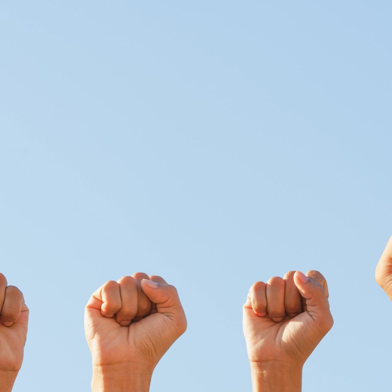 Multiple women's fists raised