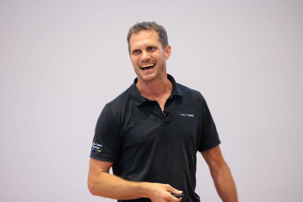 Mike Langford smiling at the front of the auditorium