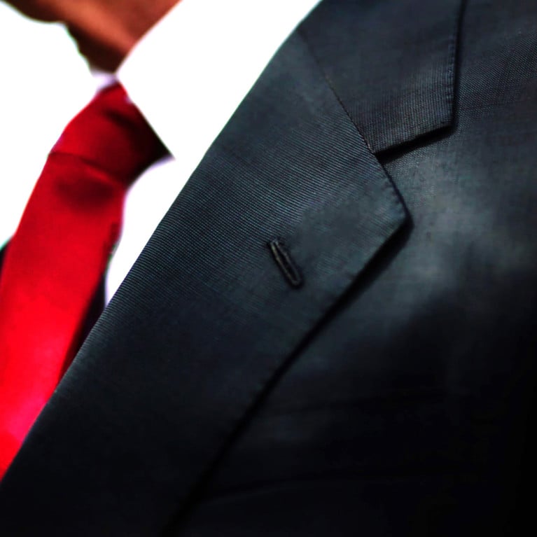 a black business suit jacket with white shirt and red tie, man neck and chest close up texture background with copy space.
By Mose Schneider Adobe Stock
