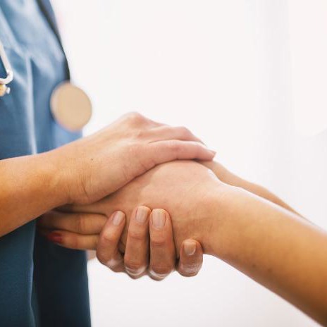 Health nurse holding patients hand