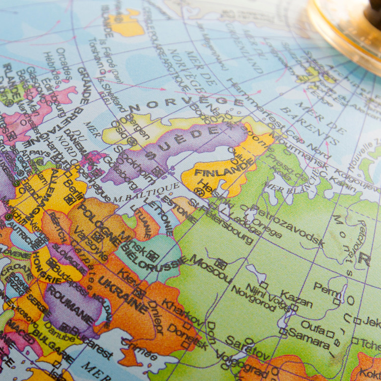 Close-up of a desktop globe showing Europe, North Africa and Central Asia, with country names in French