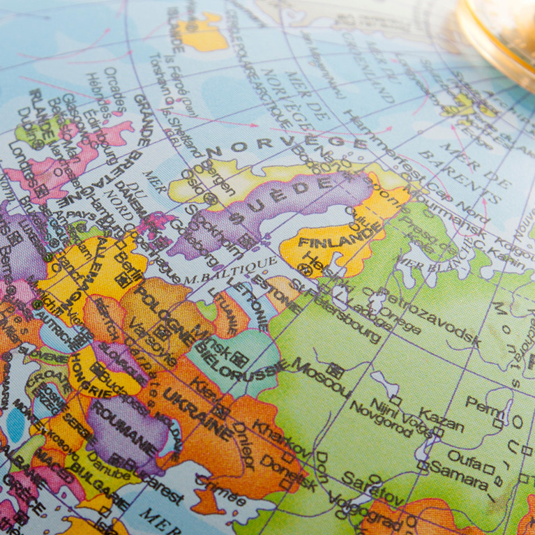 Close-up of a desktop globe showing Europe, North Africa and Central Asia, with country names in French.