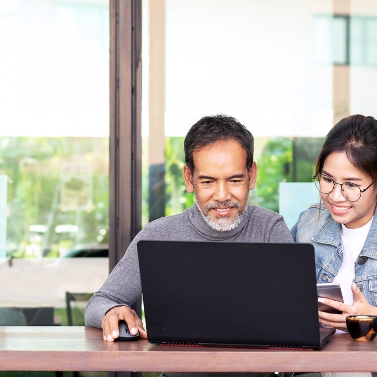 Younger student and older man looking at computer