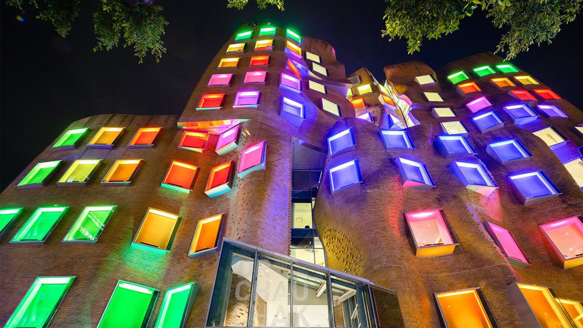 Dr Chau Chak Wing Building at night with coloured windows