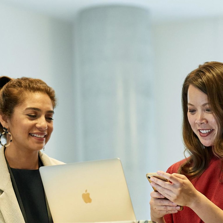 students looking at laptop and phone