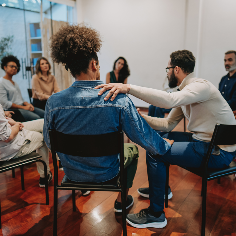 A group of people sitting in a circle facing each other and making conversation.