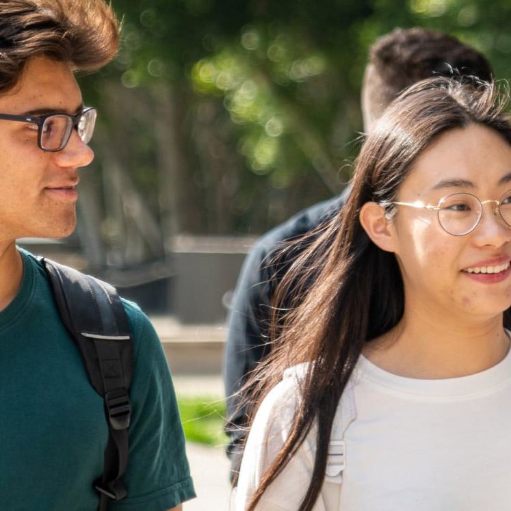 Four students walking together, chatting