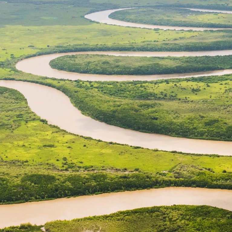a spiraling river across green plains