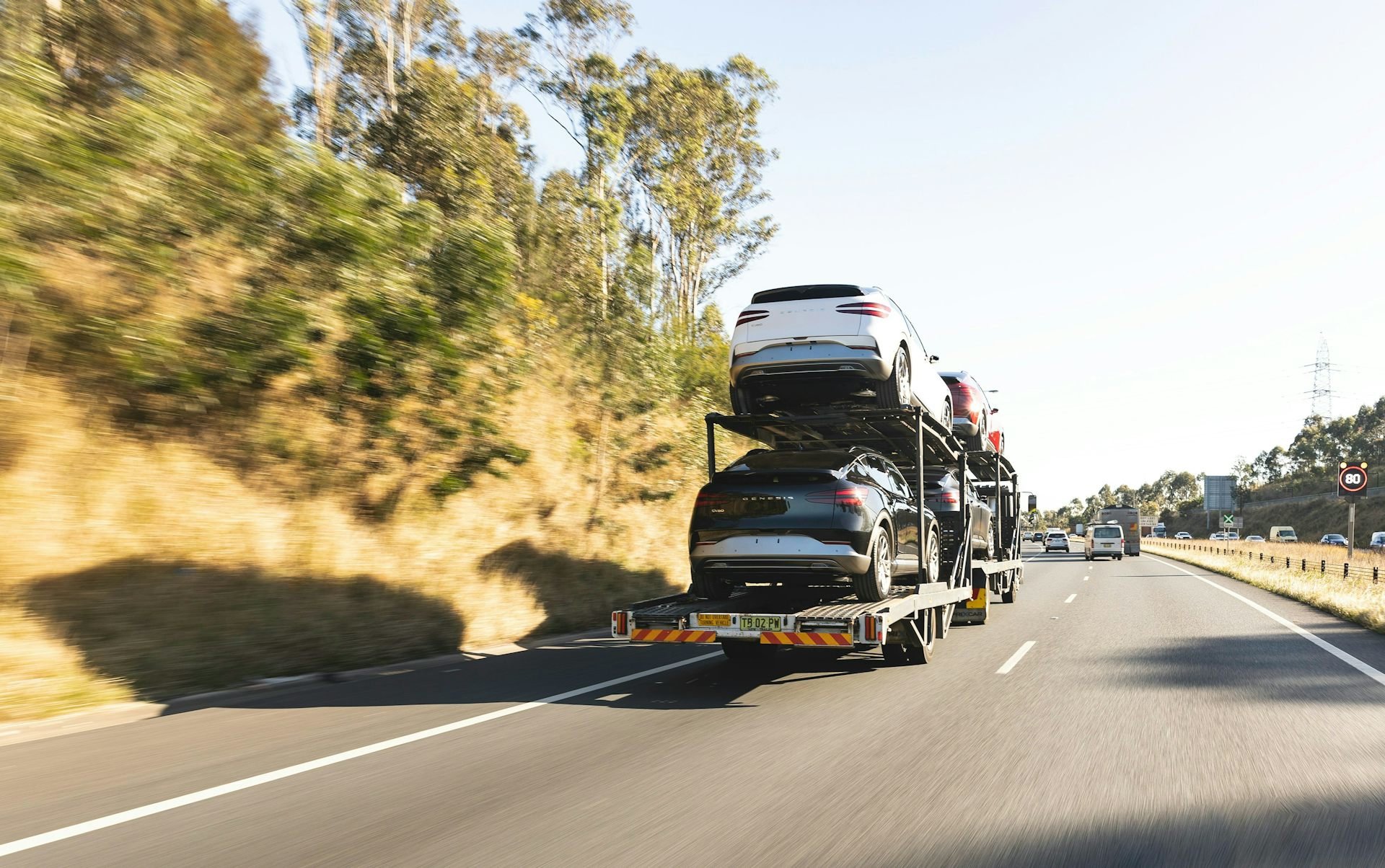 A car transport semi-trailer on the road loaded with EVs. Picture: Car Photographers/Unsplash, CC BY-NC-ND
