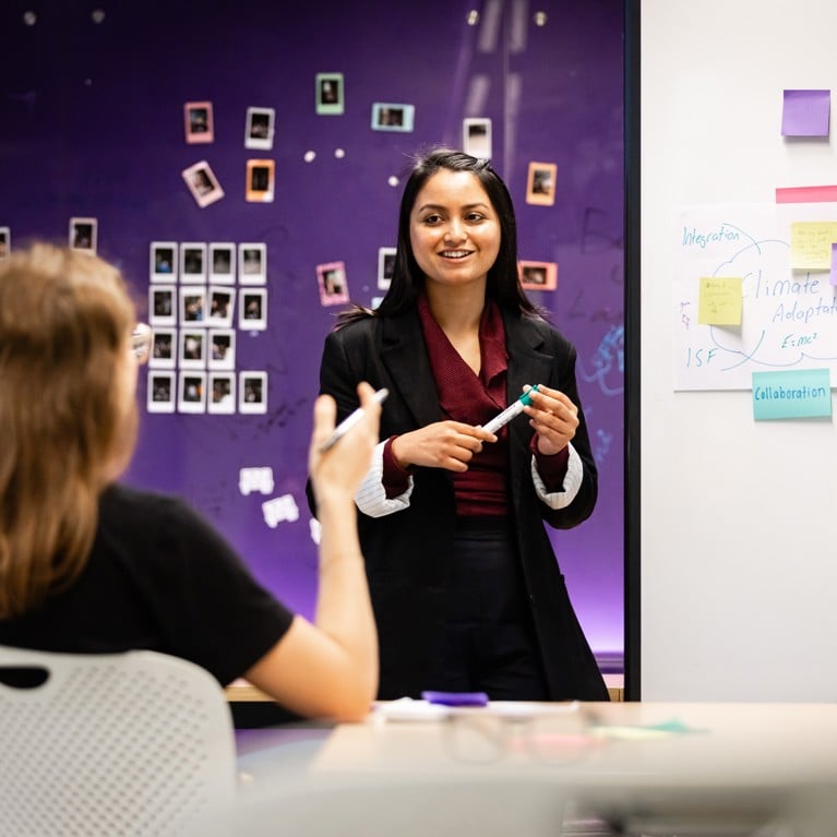 Woman conducting a workshop with post-it notes on a whiteboard