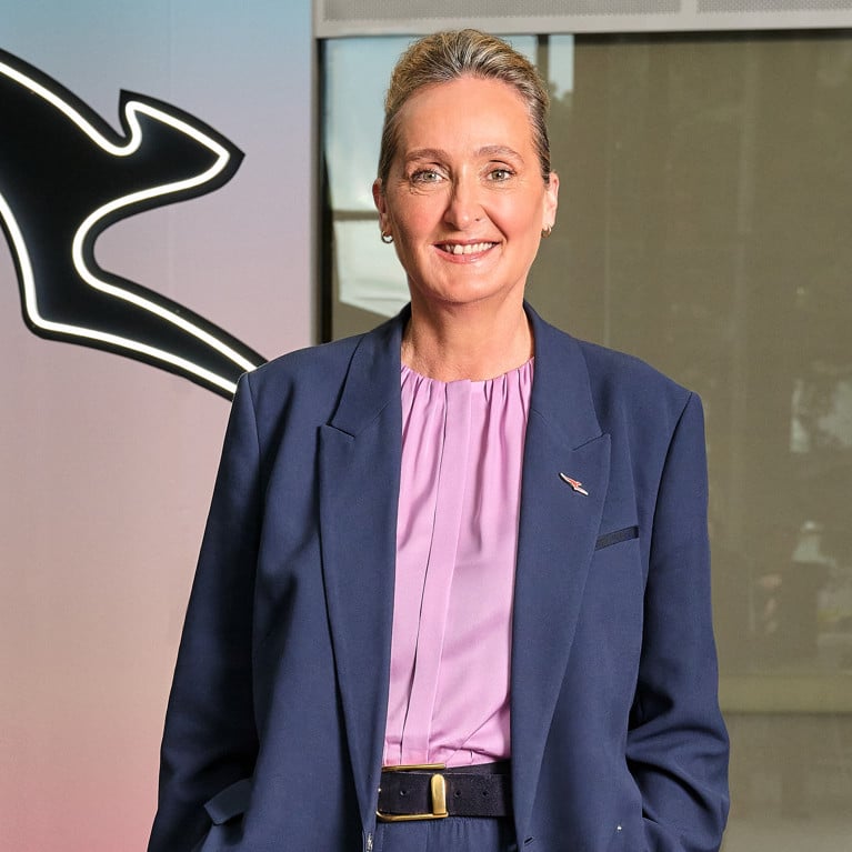 Vanessa Hudson standing in front of Qantas logo