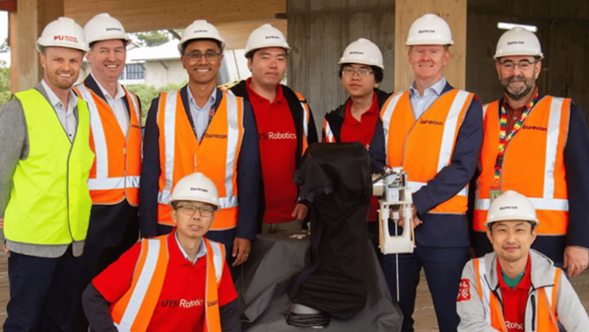 Seven men dressed in construction gear posing for picture