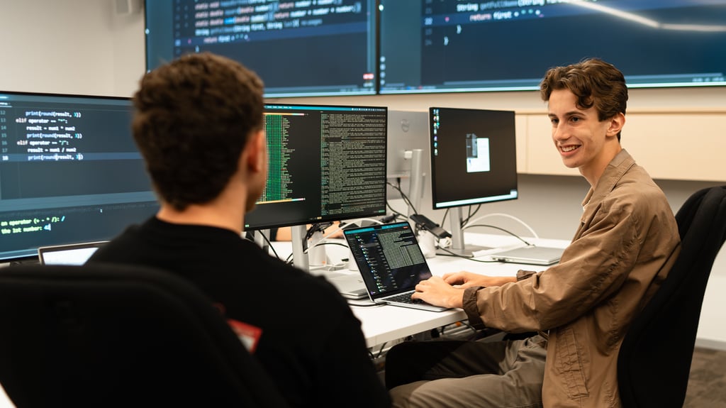 Finn Randell with his peer at the computer working on code