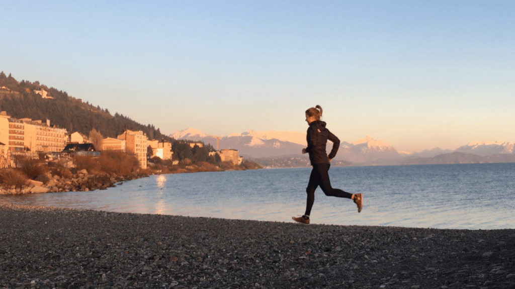 University of Technology Sydney student Alana Leabeater runs along the shore of a rocky beach.
