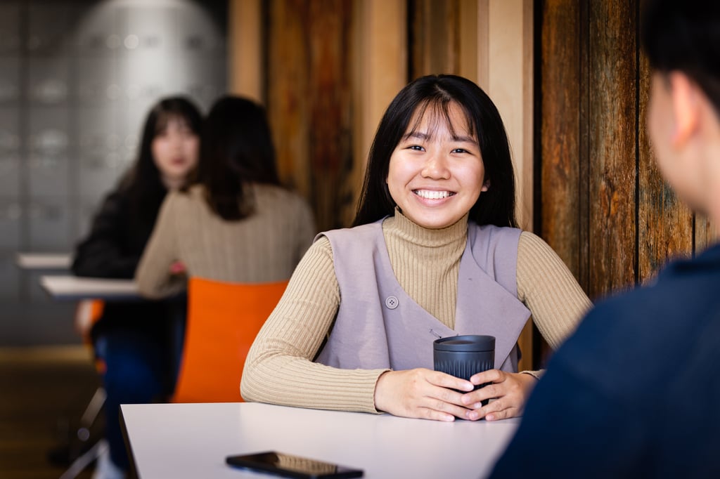 Student from UTS College holding a coffee.