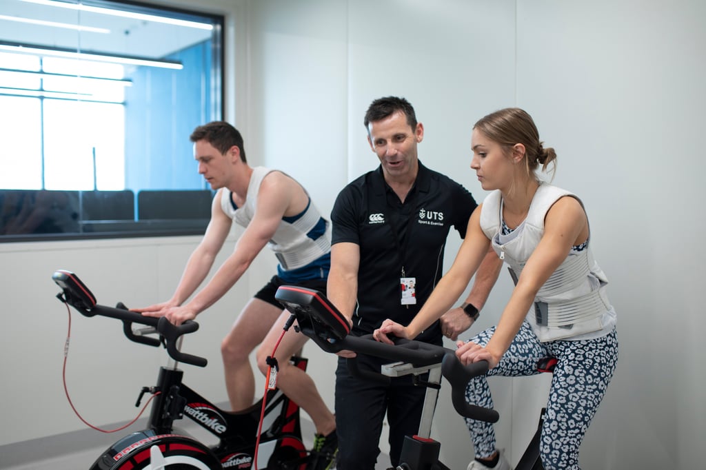 Athletes on exercise bikes are assessed by a sports and exercise specialist.