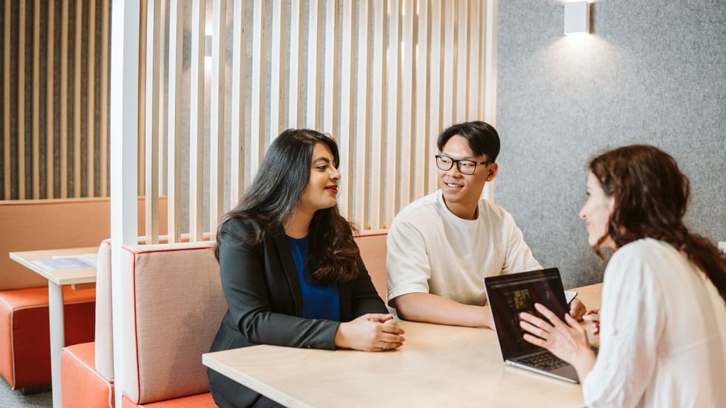 Three students talking around a table.