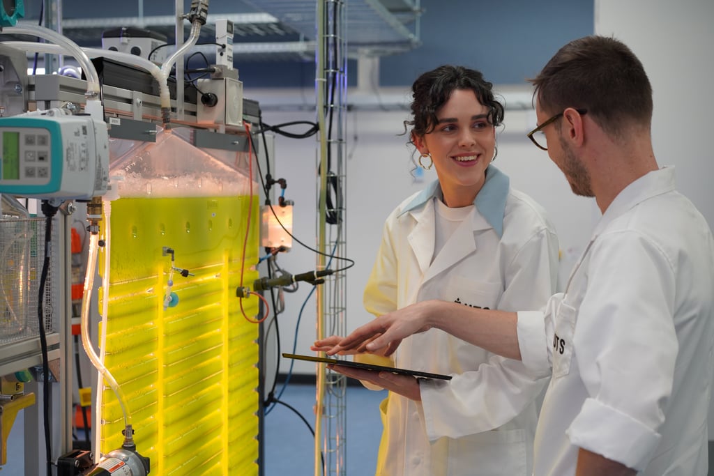 Two researchers in front of algae yellow tanks