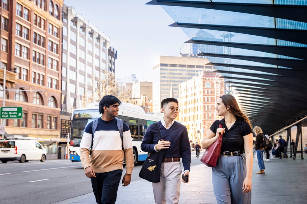 3 students walking along Railway Square, a bus interchange near UTS.
