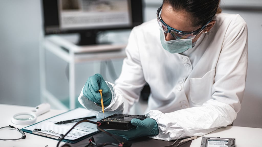 Person in white coat and mask using tools.