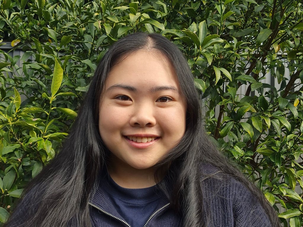 Biana Ip smiling in front of some trees.