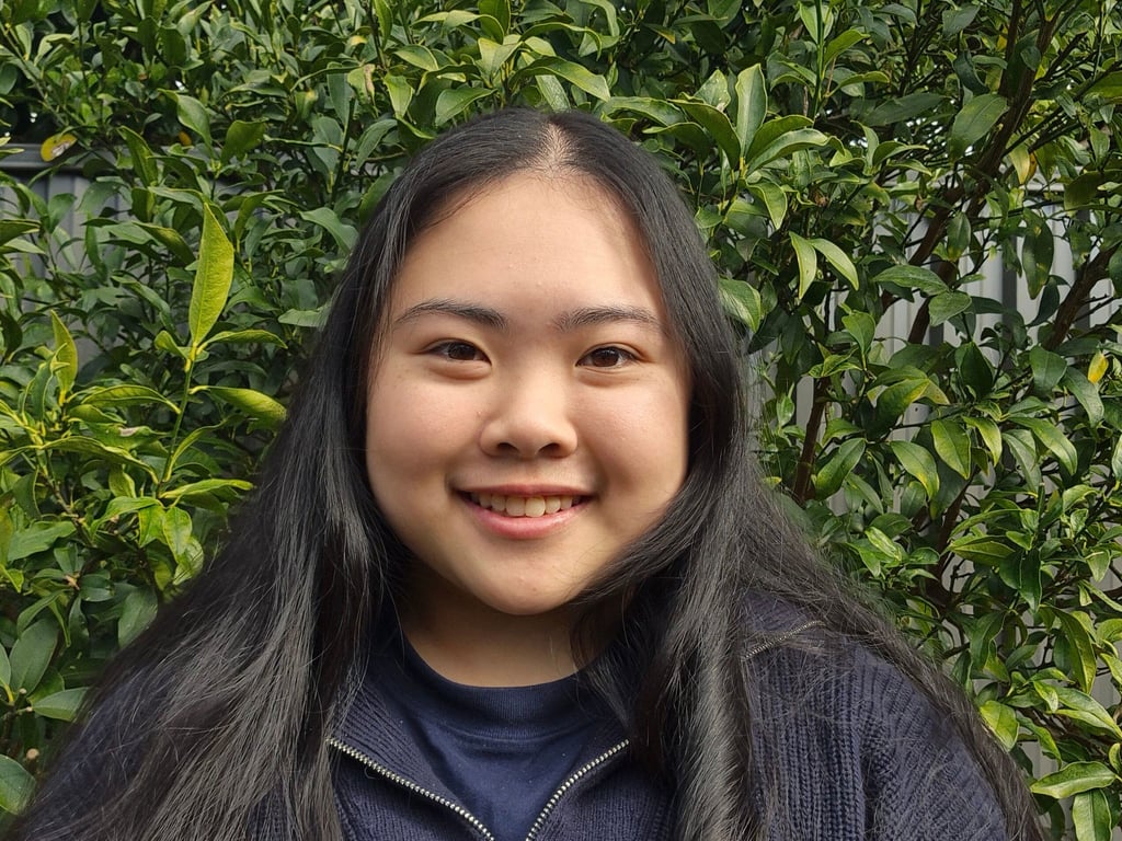 Biana Ip smiling in front of some trees.
