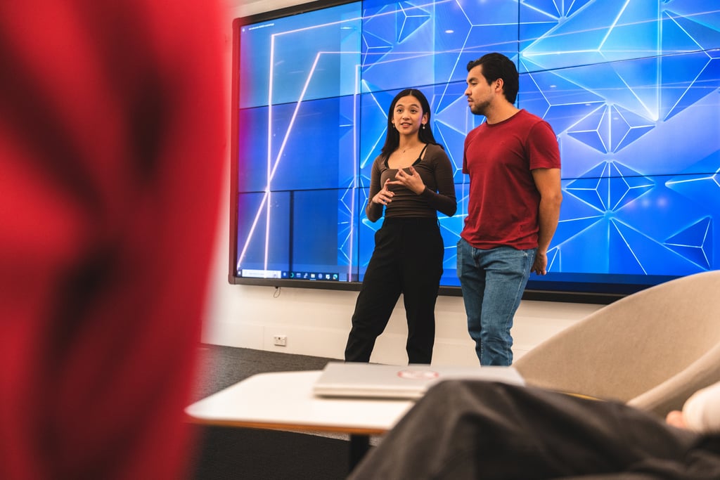 Two people standing in the Data Lounge at UTS