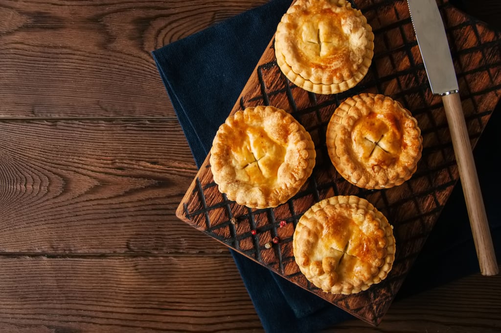 Mini meat pies from on a wooden board on a wooden table