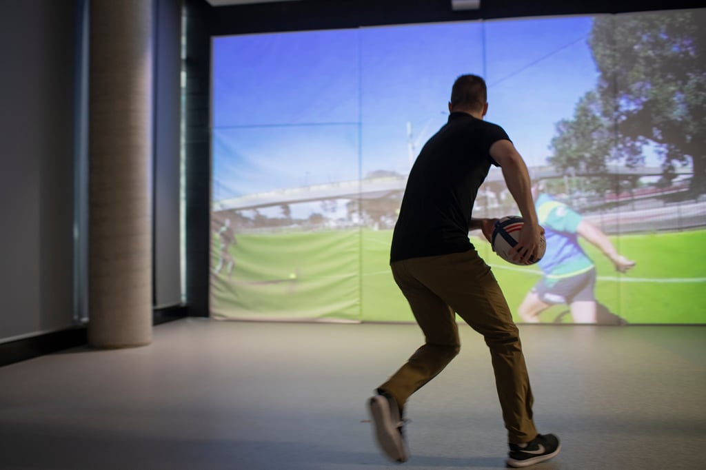 Student holding a rugby ball in the Skill Acquisition Research Laboratory