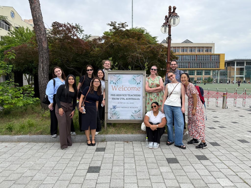 Group of students posing in front of a welcome sign that reads "Welcome Pre-service Teachers from UTS, Australia".