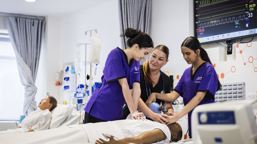 Two nursing students practice CPR on a manikin