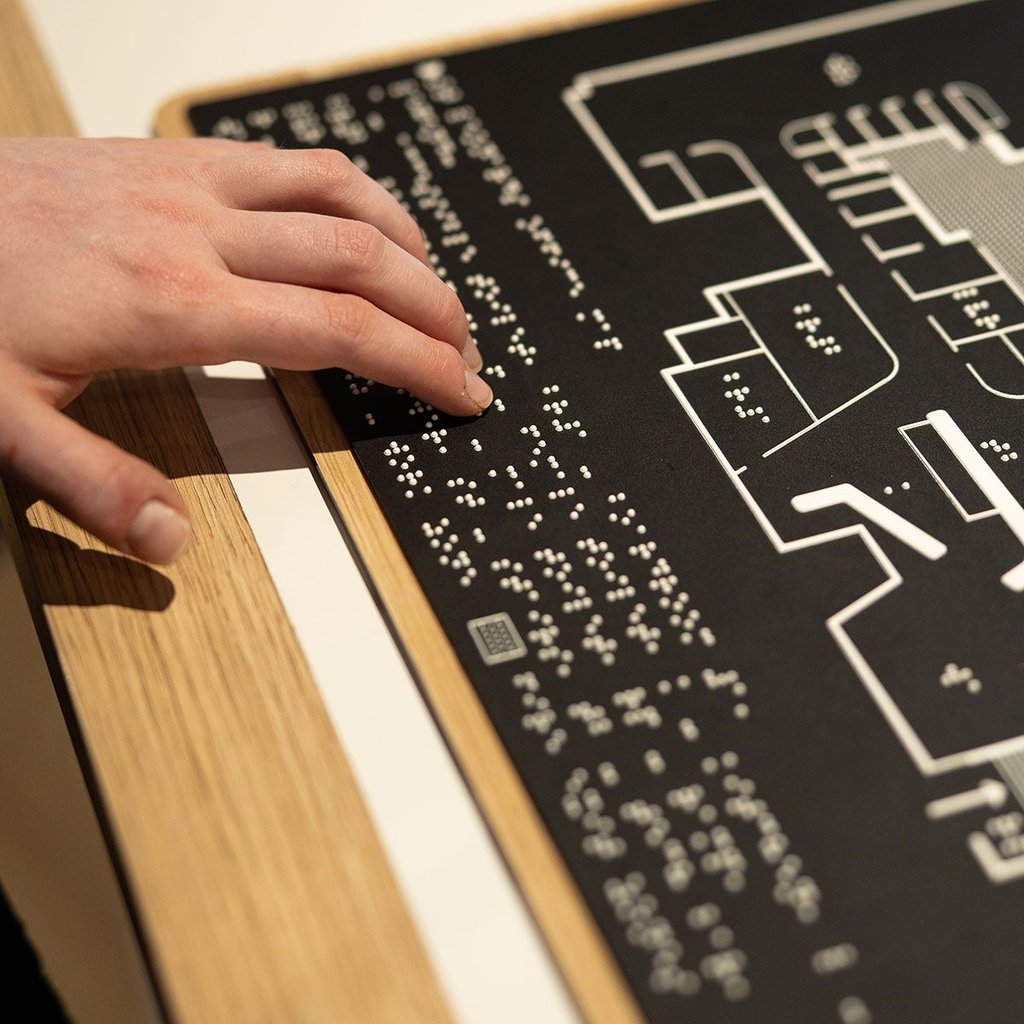 A hand travels across braille writing.