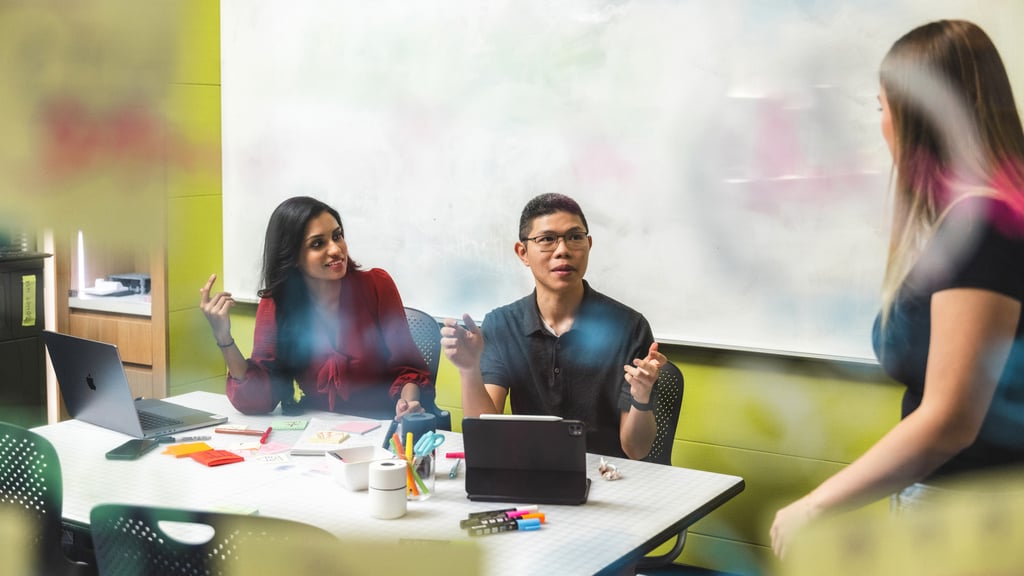 University of Technology Sydney students sitting at an office table discussing ideas.