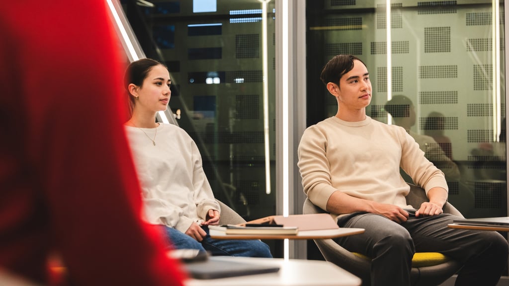 Two people listen to a presentation in the Data Lounge